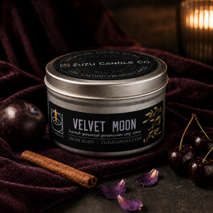 Velvet Moon candle styled on plum velvet with dark fruit and cinnamon